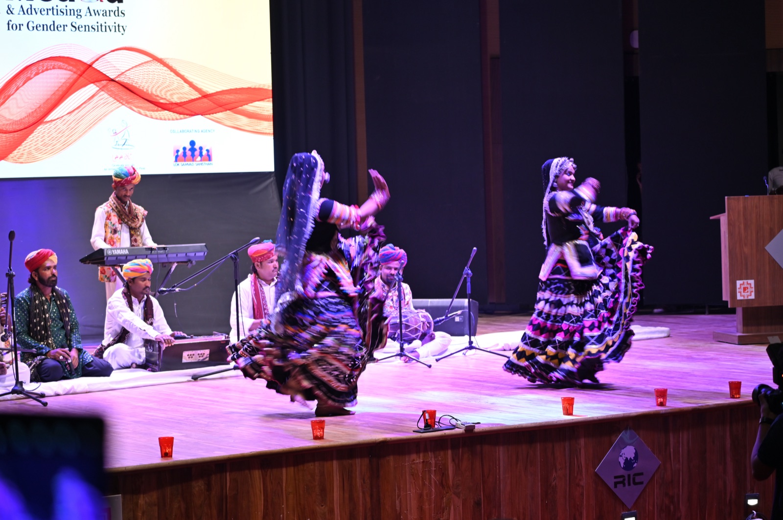 Rajasthani folk dancers performing on stage with musicians